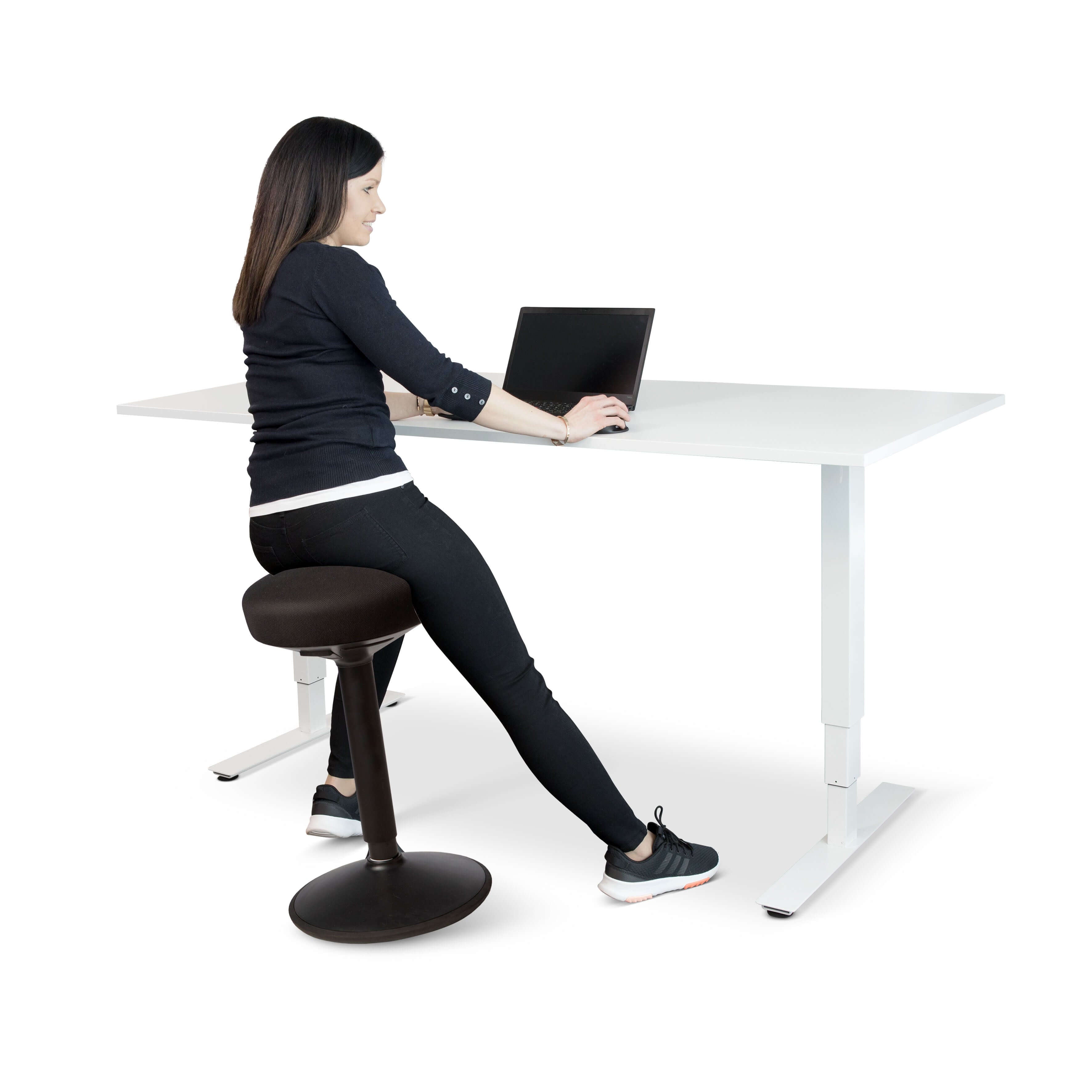 Woman using FitSit activity chair at adjustable desk, promoting ergonomic posture with black fabric seat.