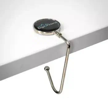 Metal workstation hook attached to table edge for hanging mats or bags.