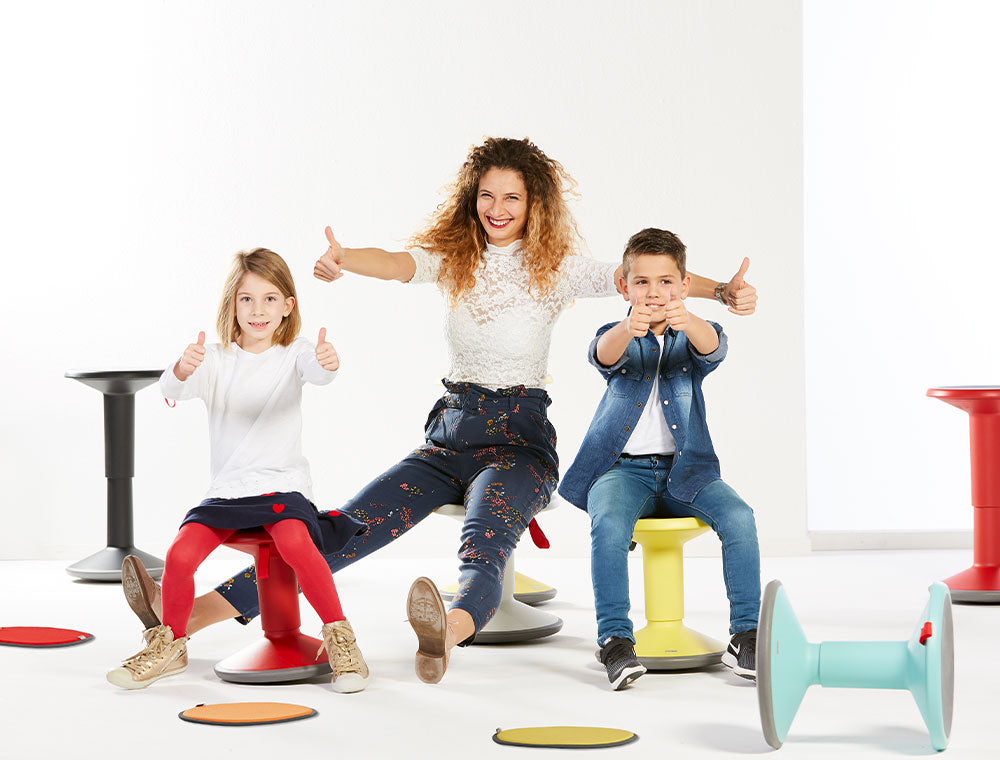 Family enjoying UPis1 90 Junior stools in various colors, showcasing ergonomic design and playful seating for kids and adults.